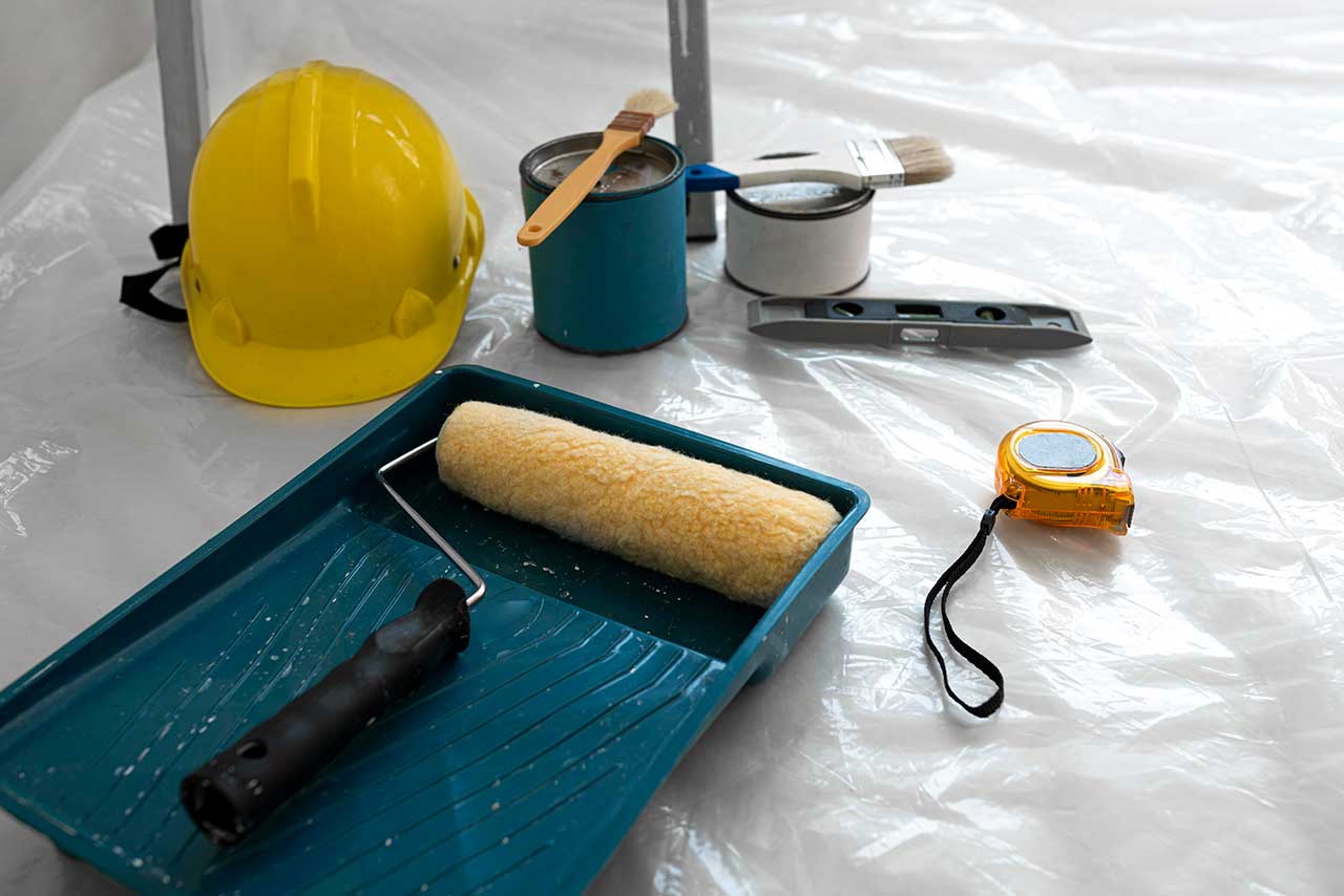 House paint accessories/tools -paint roller, yellow safety helmet, tins with paints, brushes